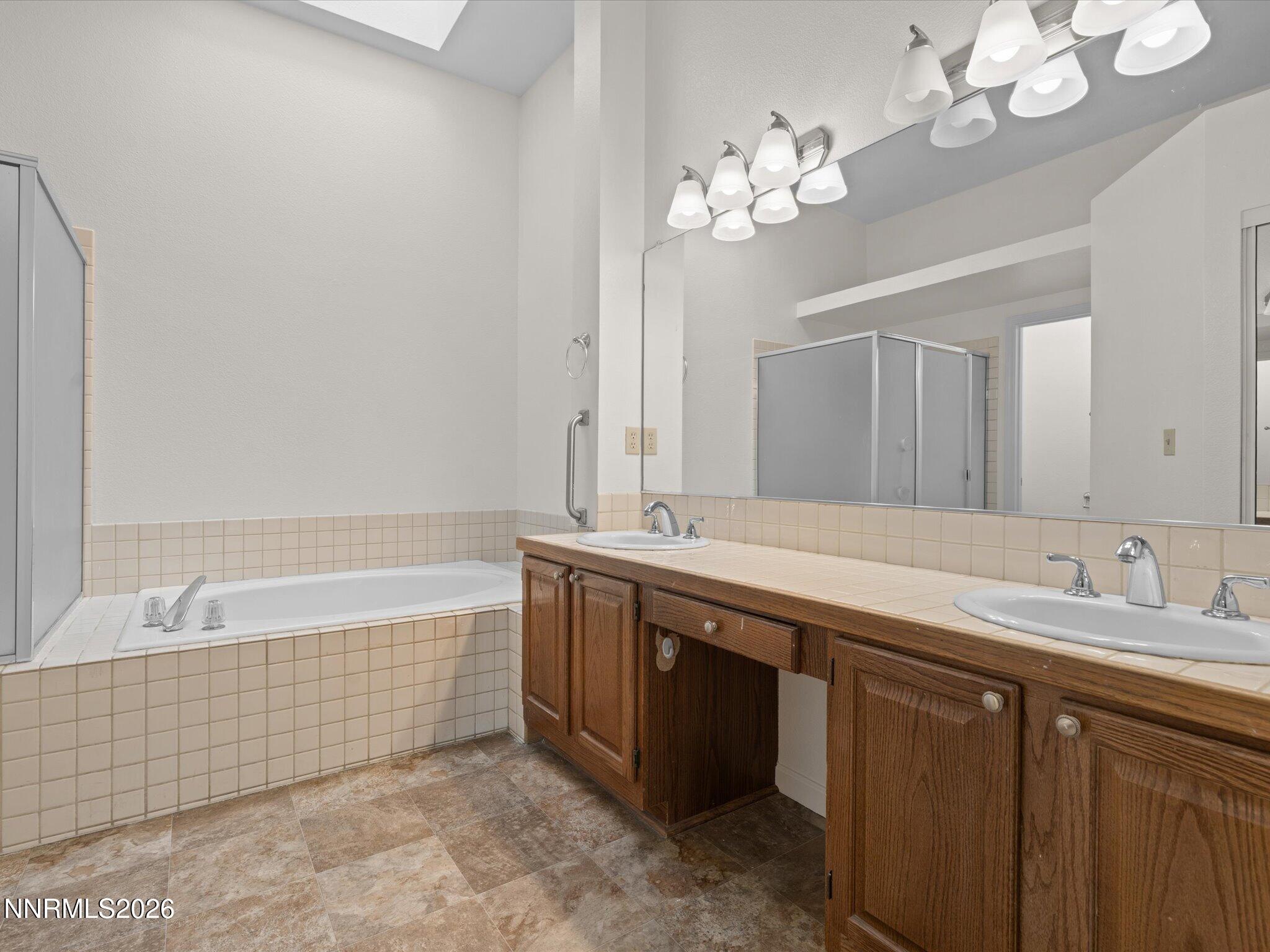 1280 Bridlewood Way Reno, NV 89509 - Photo 30 of 57 a spacious bathroom with a granite countertop bathtub a sink and a mirror