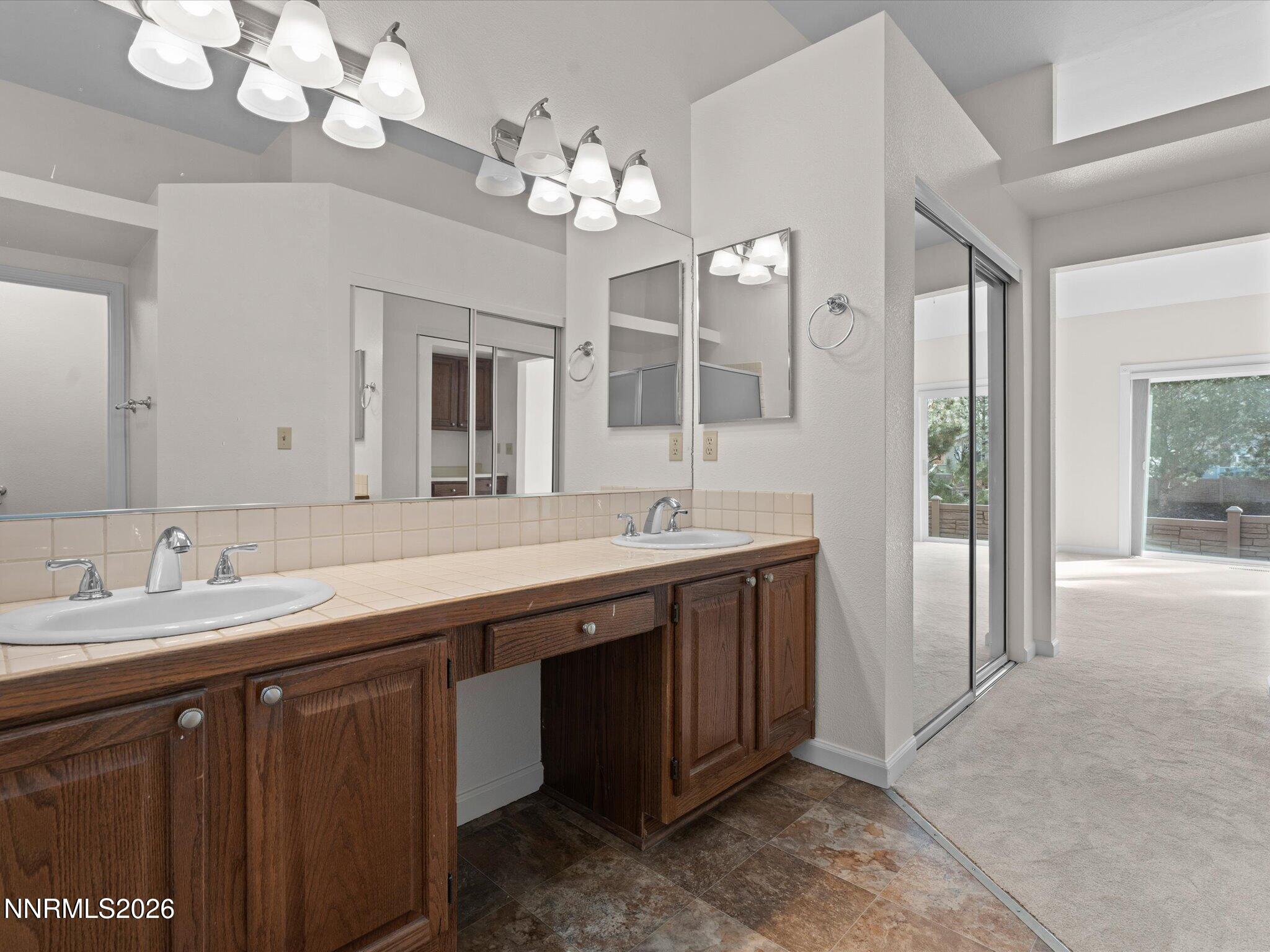 1280 Bridlewood Way Reno, NV 89509 - Photo 31 of 57 a spacious bathroom with a granite countertop double vanity sink and a mirror