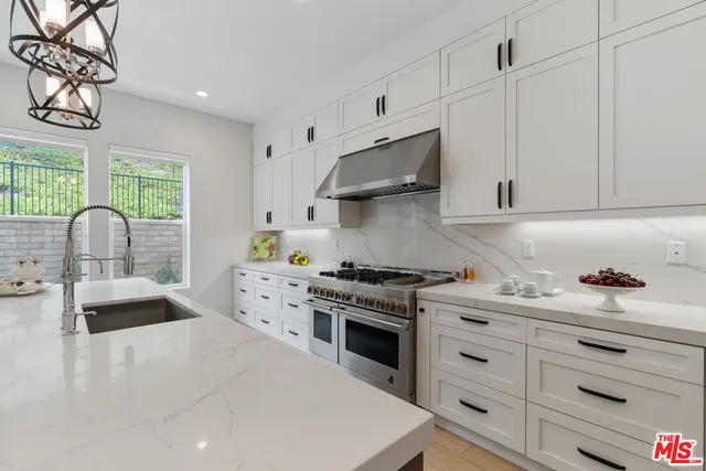 a kitchen with granite countertop a sink a stove and cabinets