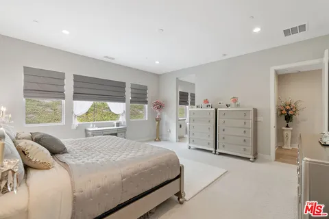 a bedroom with a bed and a large window
