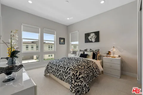 a bedroom with a bed a couch and a large window