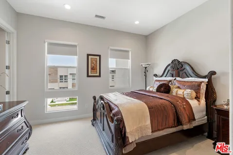 a bedroom with a bed and painting on the wall