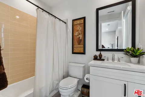a bathroom with a sink toilet a mirror and shower