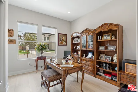 a living room with furniture a bookshelf and a window