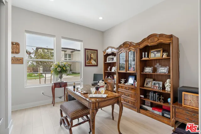 a living room with furniture a bookshelf and a window