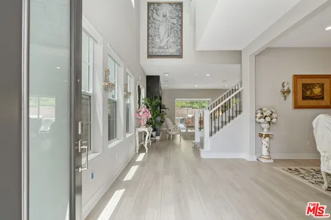 a view of a hallway to a livingroom with furniture and wooden floor