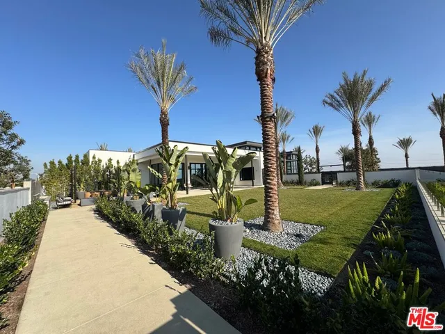 a view of a fountain in front of a house with a yard