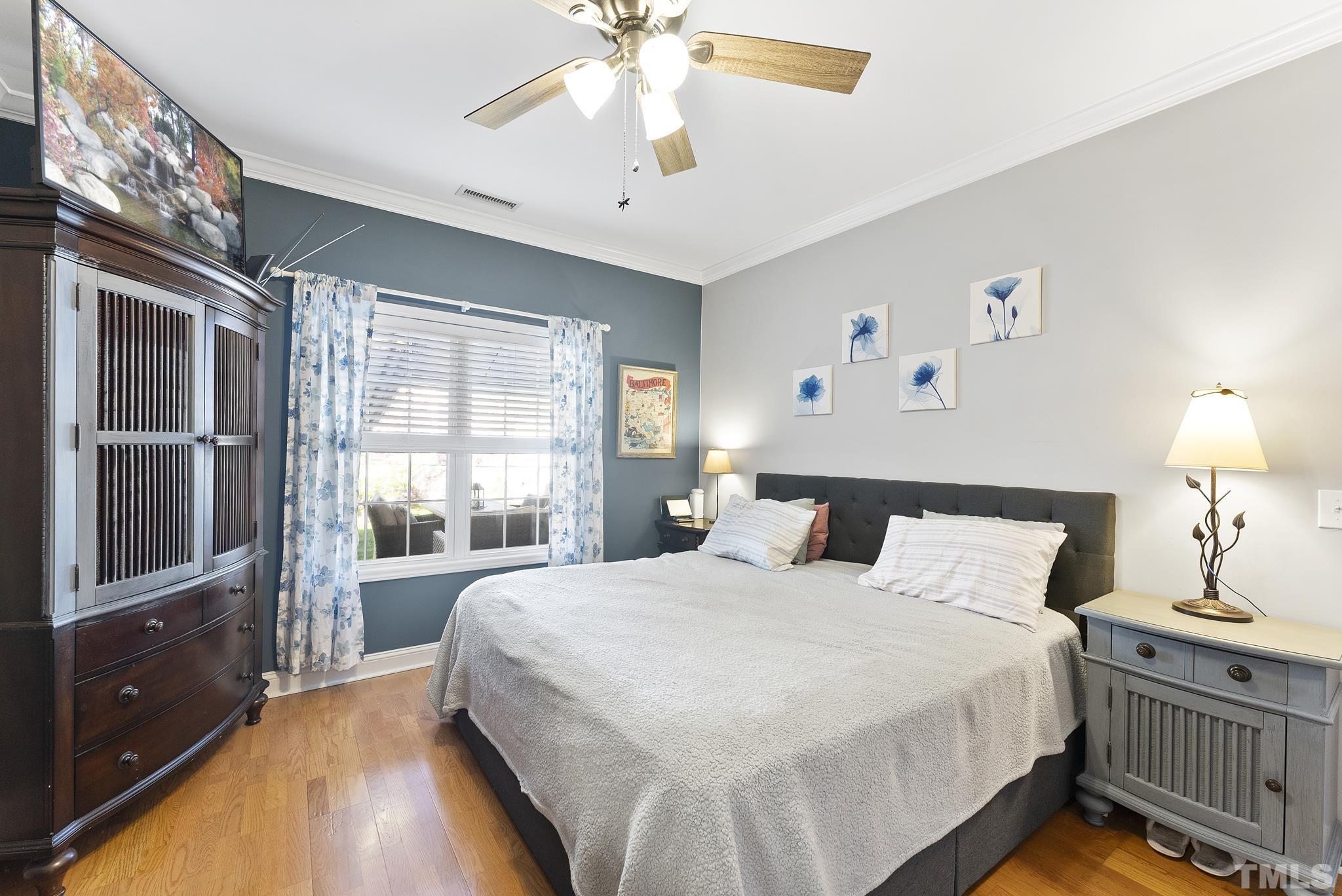 5016 Village Lawn Drive Raleigh, NC 27613 - Photo 11 of 27 a bedroom with a large bed and a chandelier