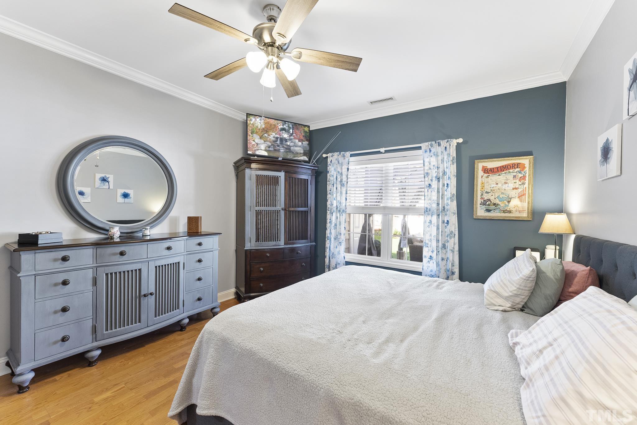 5016 Village Lawn Drive Raleigh, NC 27613 - Photo 12 of 27 a bedroom with a large bed and a chandelier