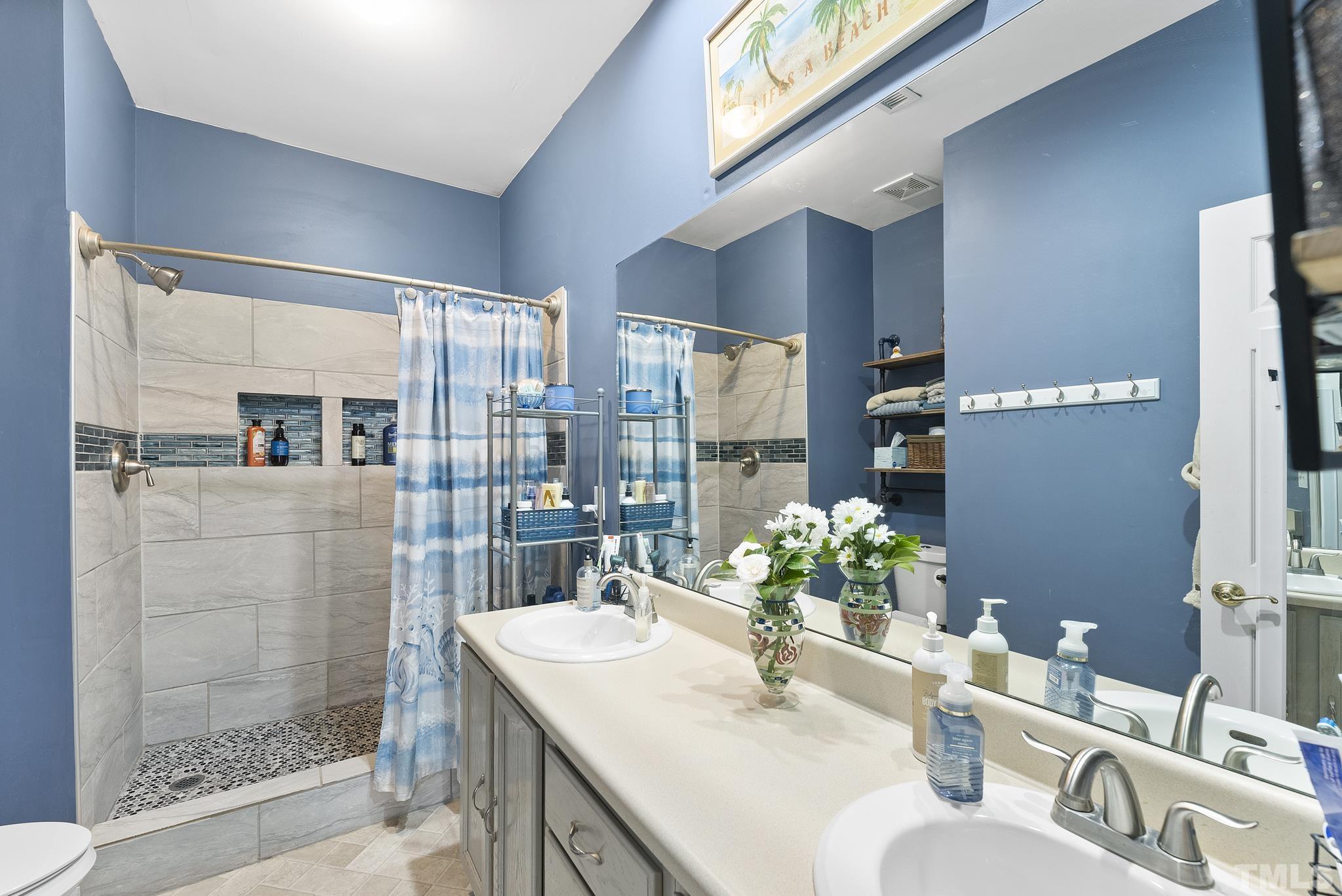 5016 Village Lawn Drive Raleigh, NC 27613 - Photo 13 of 27 a bathroom with a granite countertop sink mirror and shower