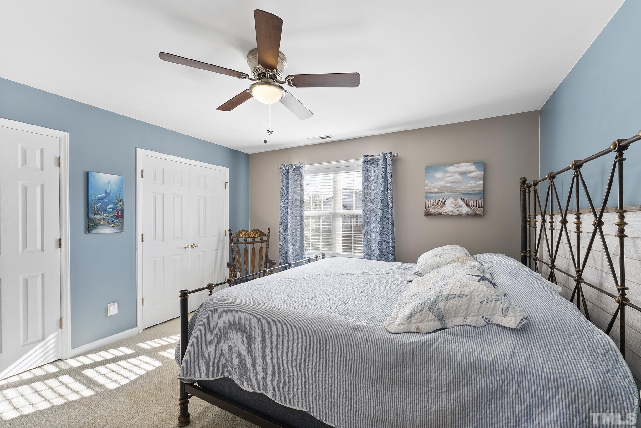 5016 Village Lawn Drive Raleigh, NC 27613 - Photo 16 of 27 a bedroom with a large bed and a chandelier