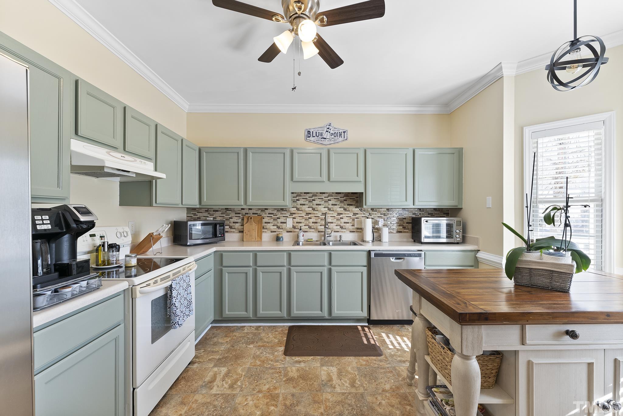 5016 Village Lawn Drive Raleigh, NC 27613 - Photo 5 of 27 a kitchen with stainless steel appliances granite countertop a sink counter space cabinets and a window