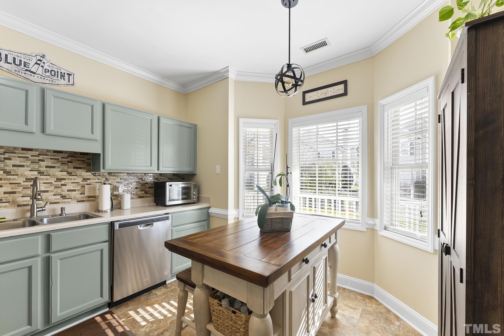 5016 Village Lawn Drive Raleigh, NC 27613 - Photo 6 of 27 a kitchen with a sink a counter top space and living room view