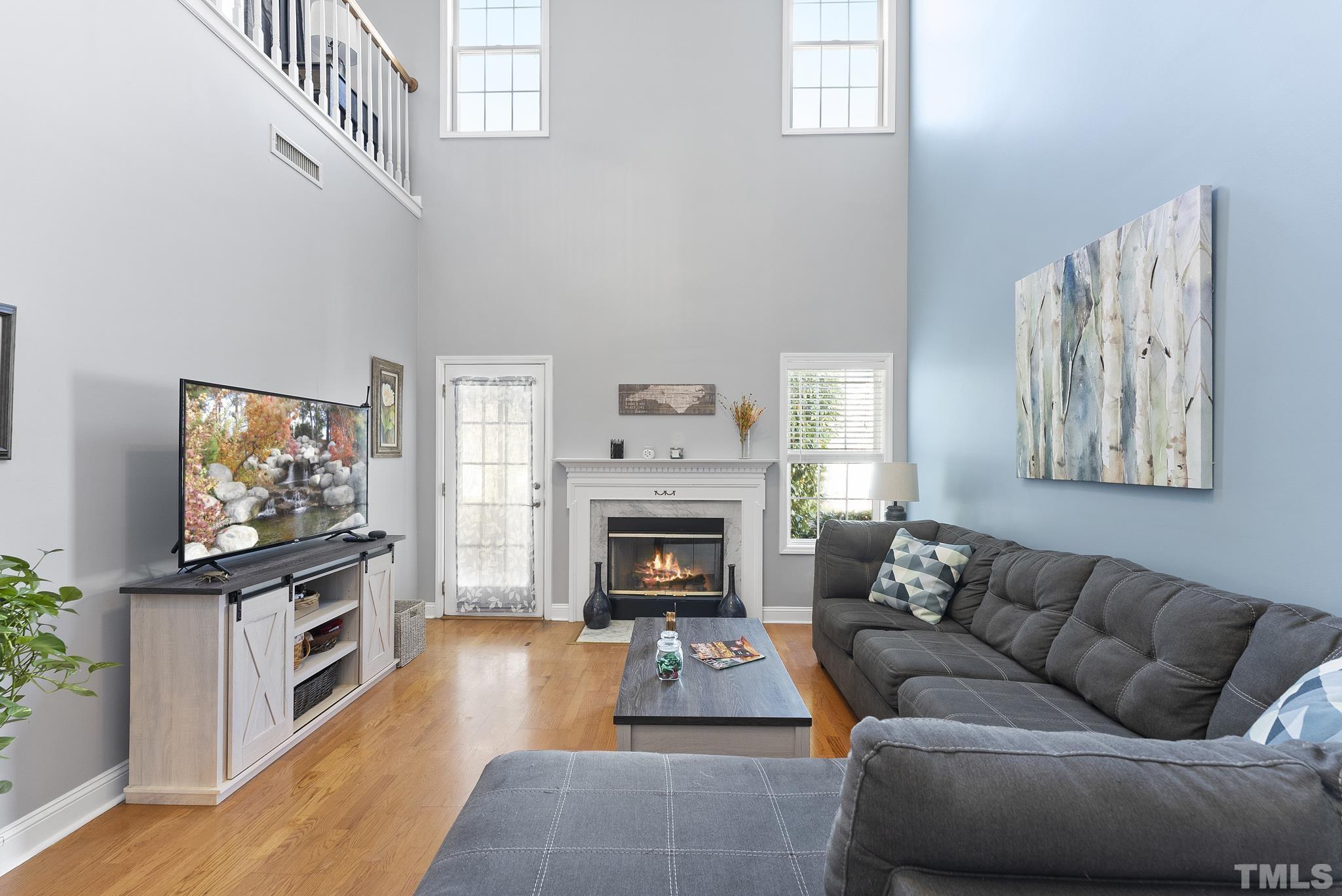 5016 Village Lawn Drive Raleigh, NC 27613 - Photo 9 of 27 a living room with furniture a flat screen tv and a fireplace