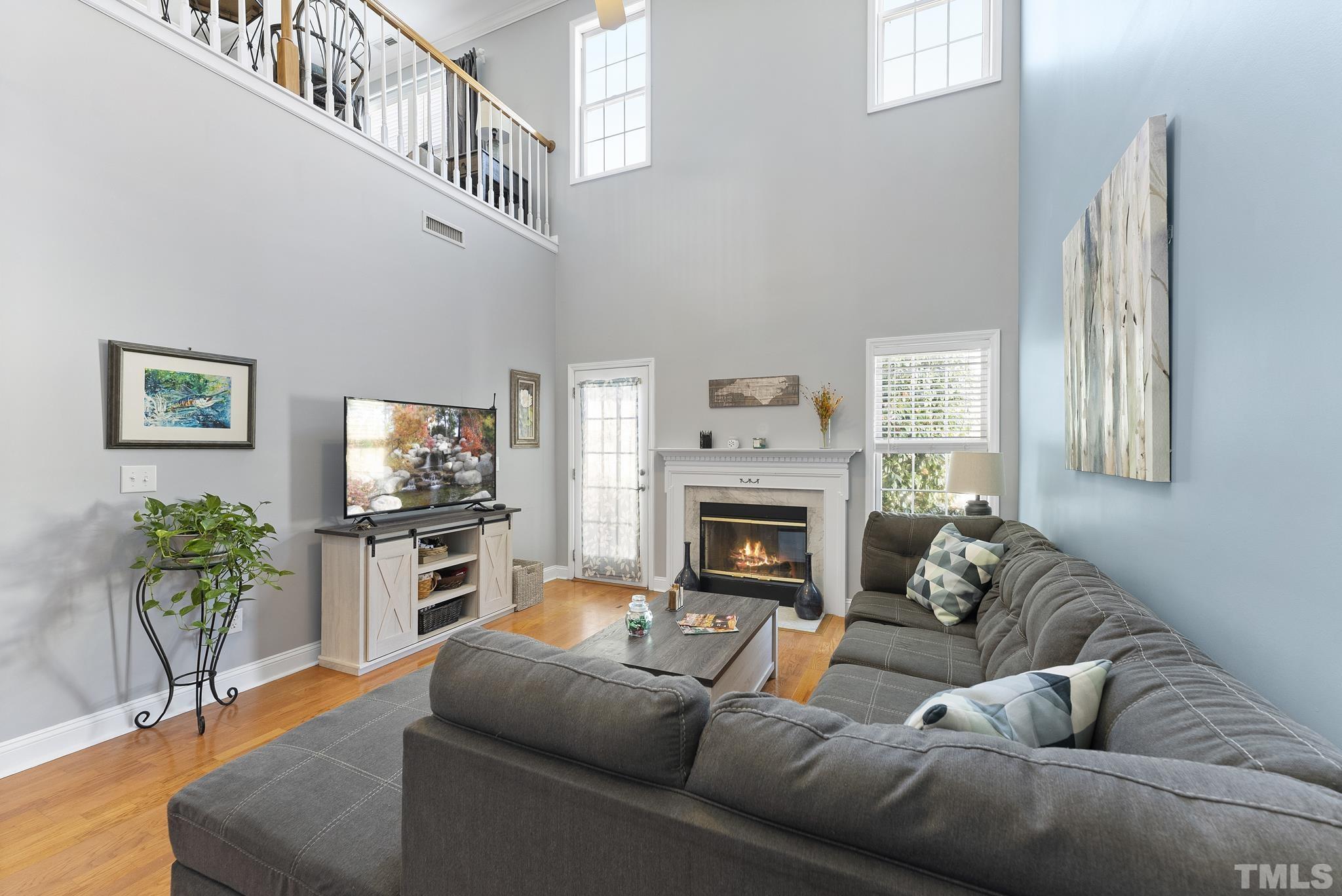 5016 Village Lawn Drive Raleigh, NC 27613 - Photo 10 of 27 a living room with furniture a flat screen tv and a fireplace