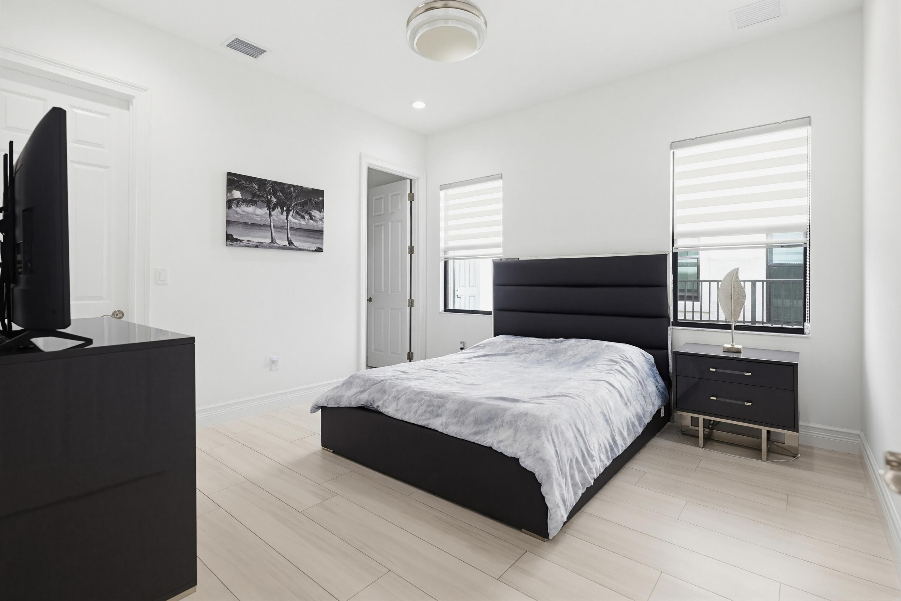 9801 Rennes Lane Delray Beach, FL 33446 - Photo 35 of 77 a bedroom with a bed and a flat screen tv