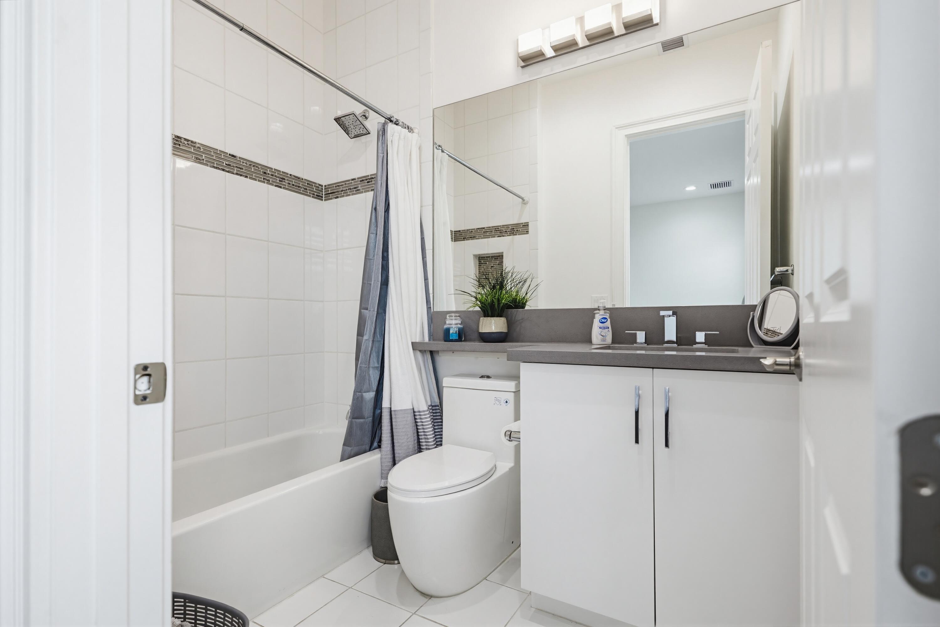 9801 Rennes Lane Delray Beach, FL 33446 - Photo 36 of 77 a bathroom with a granite countertop sink a toilet a mirror and shower