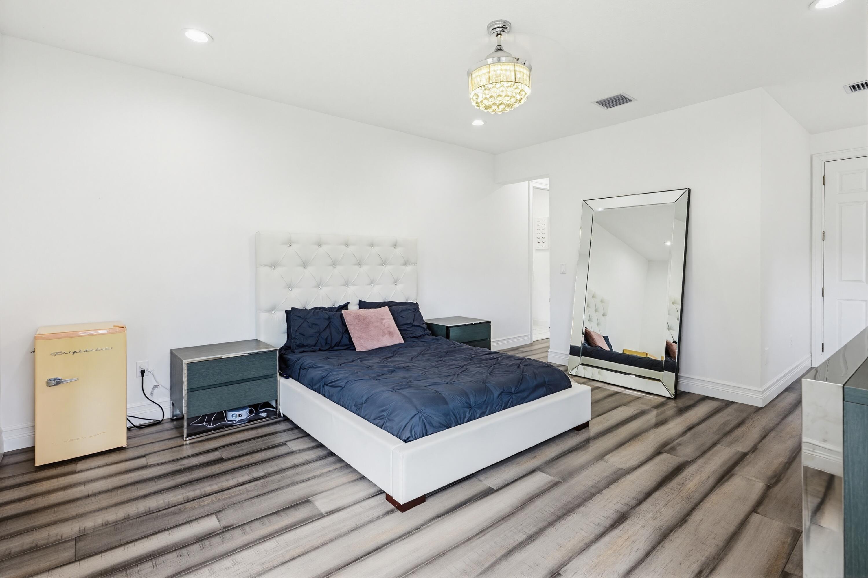 9801 Rennes Lane Delray Beach, FL 33446 - Photo 53 of 77 a living room with a bed and dresser with wooden floor