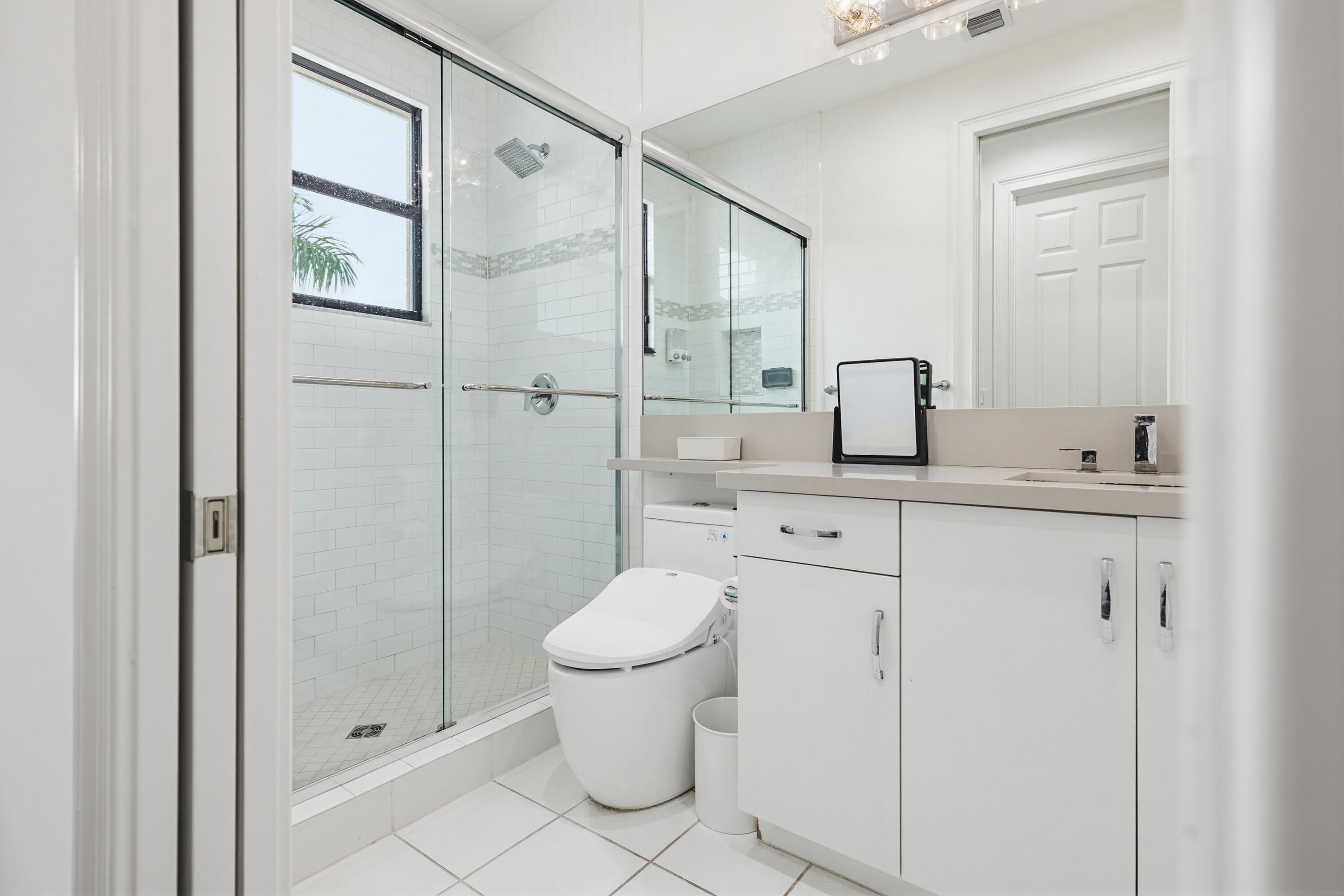 9801 Rennes Lane Delray Beach, FL 33446 - Photo 57 of 77 a bathroom with a granite countertop sink a toilet and shower
