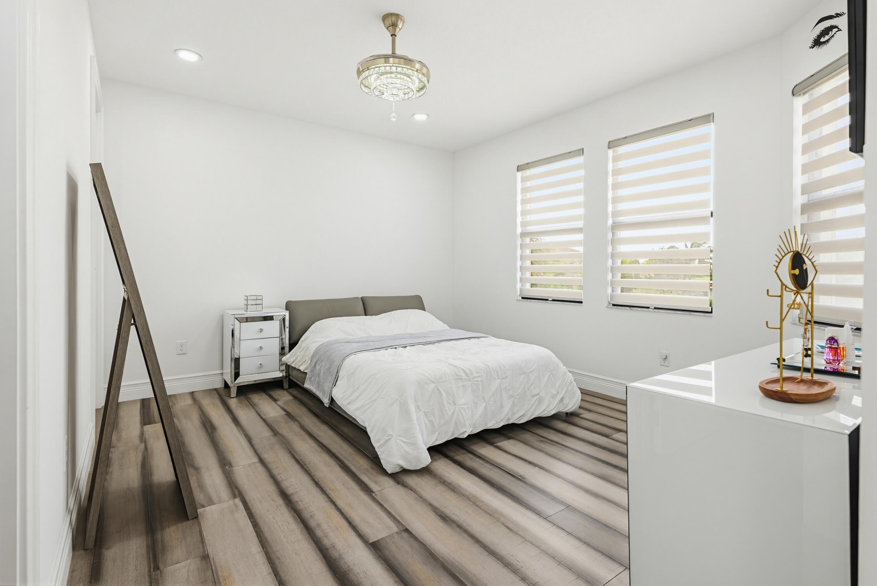 9801 Rennes Lane Delray Beach, FL 33446 - Photo 61 of 77 a bedroom with a bed and wooden floor