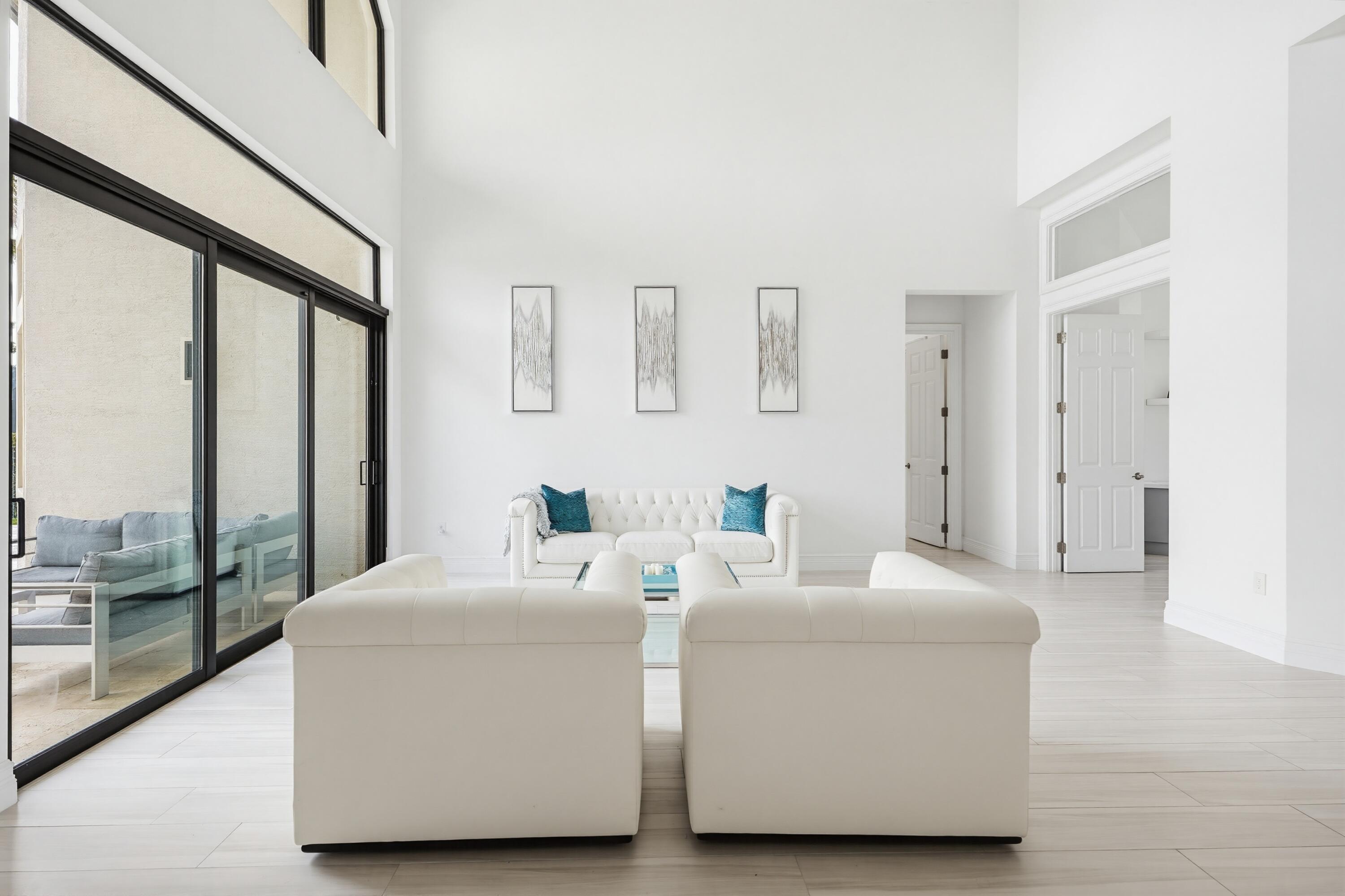 9801 Rennes Lane Delray Beach, FL 33446 - Photo 7 of 77 a living room with furniture and a floor to ceiling window