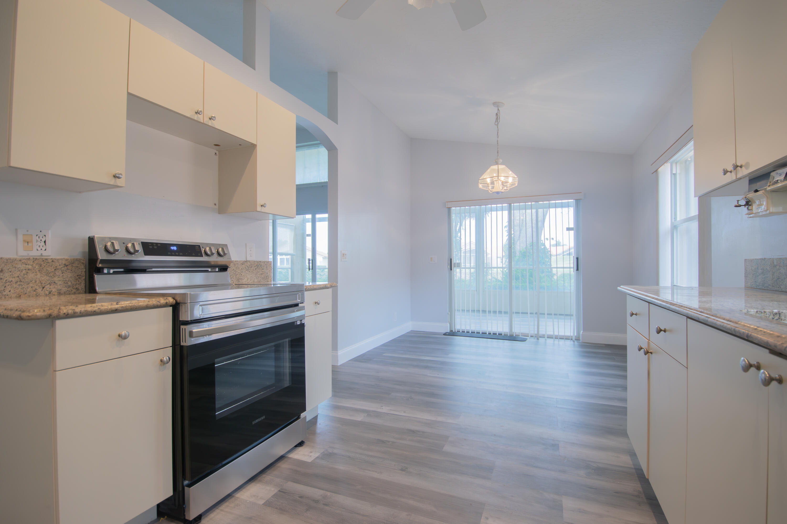 7243 Modena Drive Boynton Beach, FL 33437 - Photo 7 of 28 a kitchen with granite countertop a stove and a wooden floors