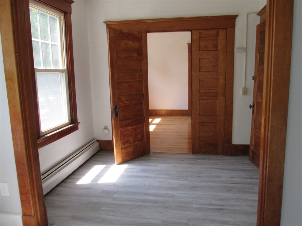 5 Oberlin Street, Unit 2 Worcester, MA 01610 - Photo 11 of 22 an empty room with wooden floor and windows