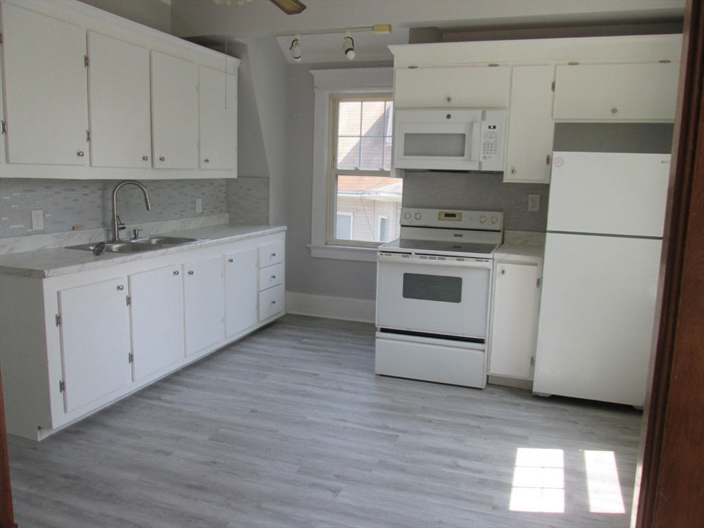 5 Oberlin Street, Unit 2 Worcester, MA 01610 - Photo 17 of 22 a kitchen with granite countertop white cabinets and white appliances