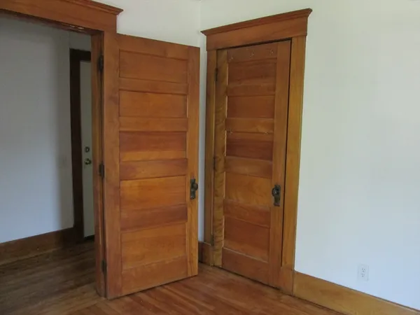 an empty room with wooden floor and closet