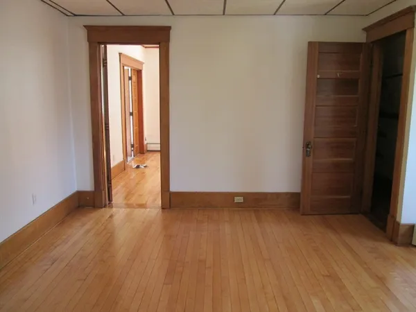 an empty room with wooden floor and closet