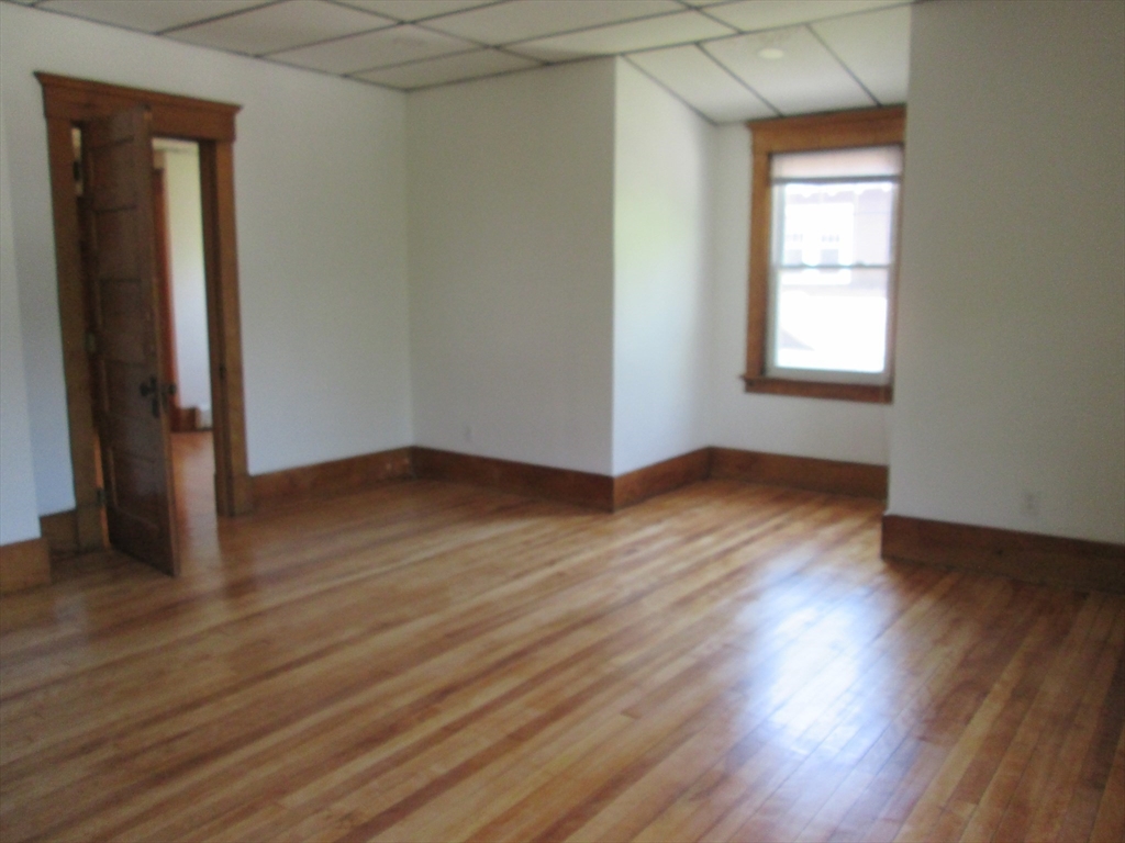 5 Oberlin Street, Unit 2 Worcester, MA 01610 - Photo 8 of 22 an empty room with wooden floor and windows