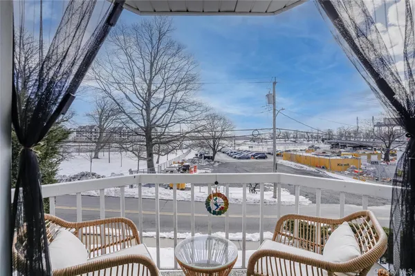 a view of a balcony with dining table and chairs