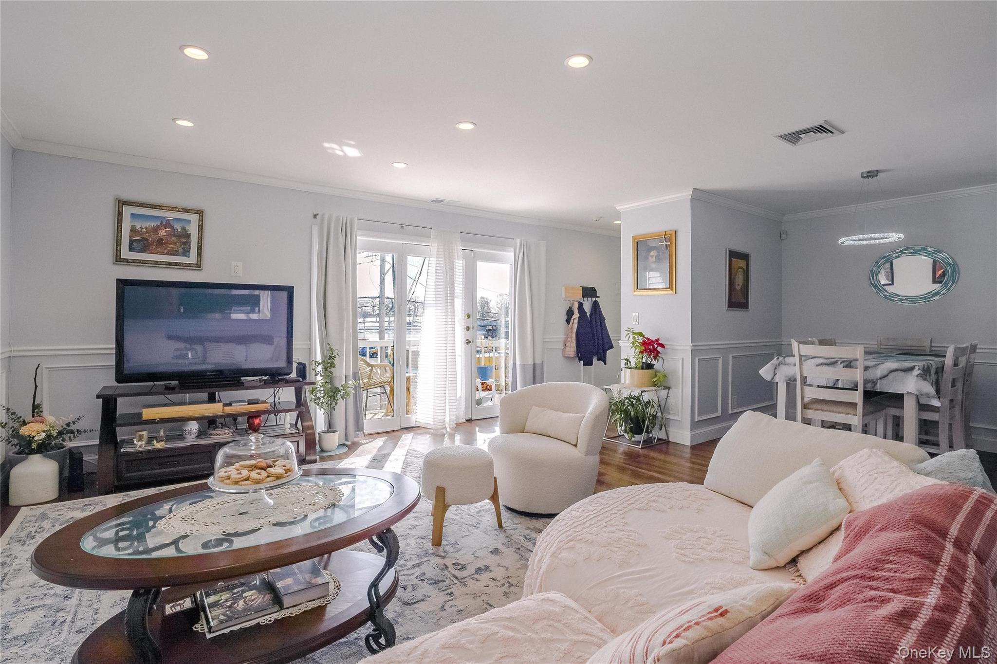 37 Harbor Lane, Unit 2C New Rochelle, NY 10805 - Photo 3 of 17 a living room with furniture a flat screen tv and a dining table