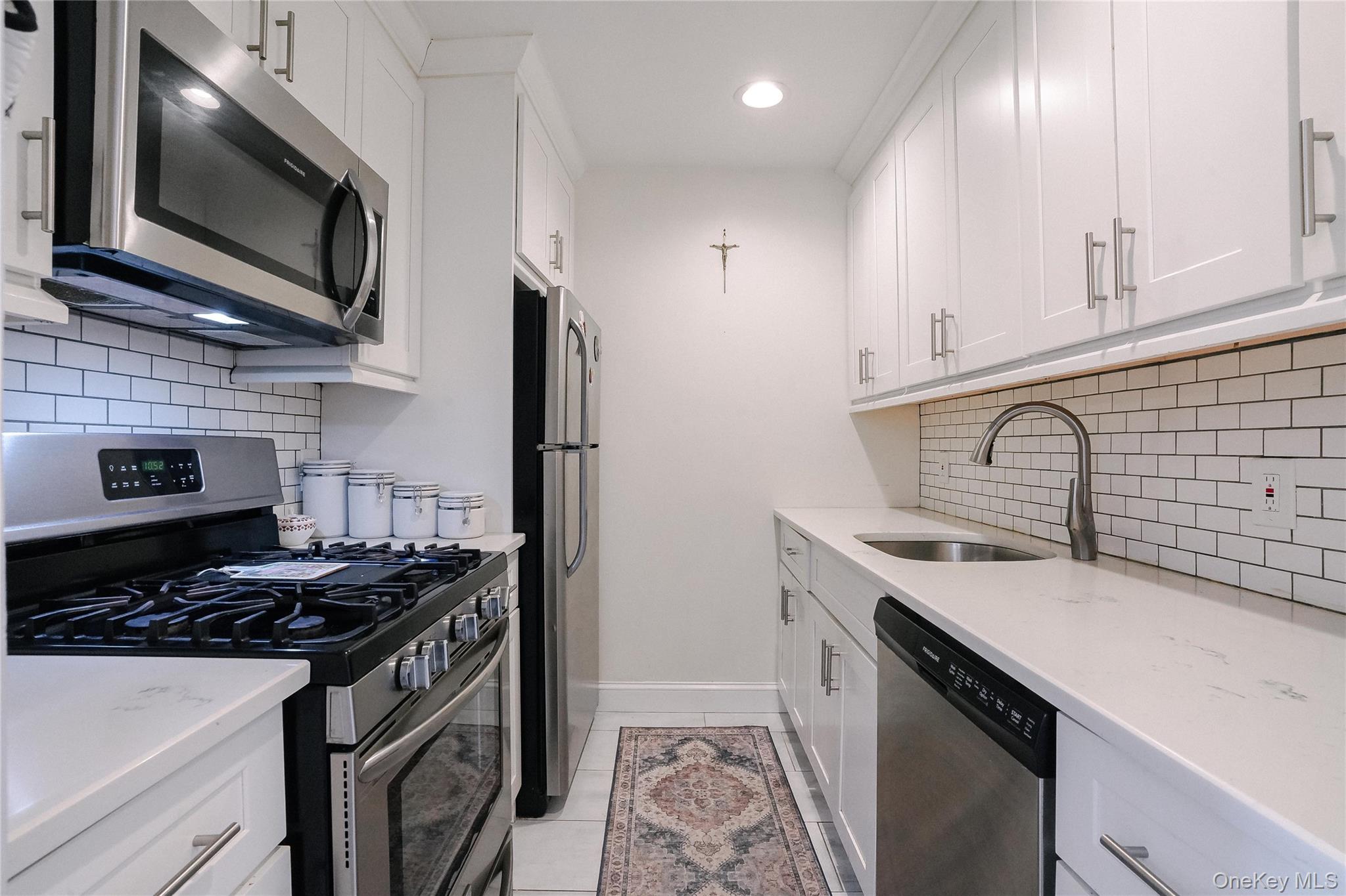37 Harbor Lane, Unit 2C New Rochelle, NY 10805 - Photo 6 of 17 a kitchen with stainless steel appliances a sink stove and refrigerator