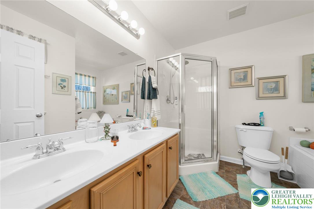 195 Maple Court Alburtis, PA 18011 - Photo 14 of 21 a spacious bathroom with a sink a toilet a mirror and shower
