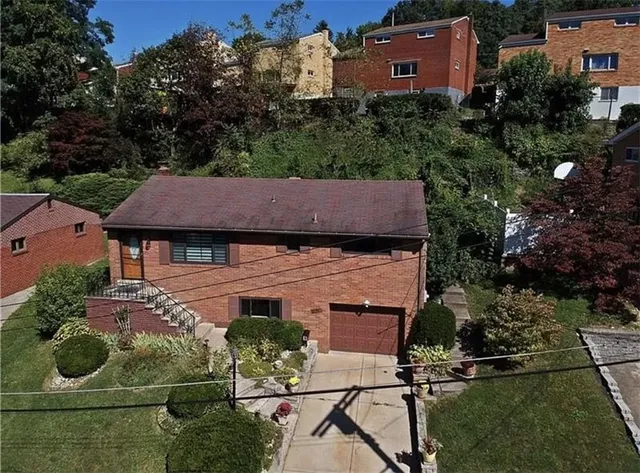an aerial view of a house with garden space and street view