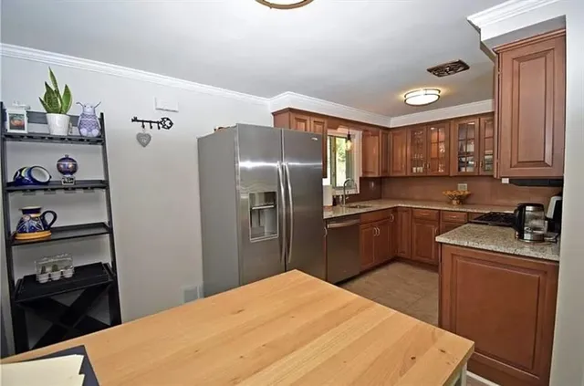 a kitchen with stainless steel appliances a refrigerator sink and cabinets