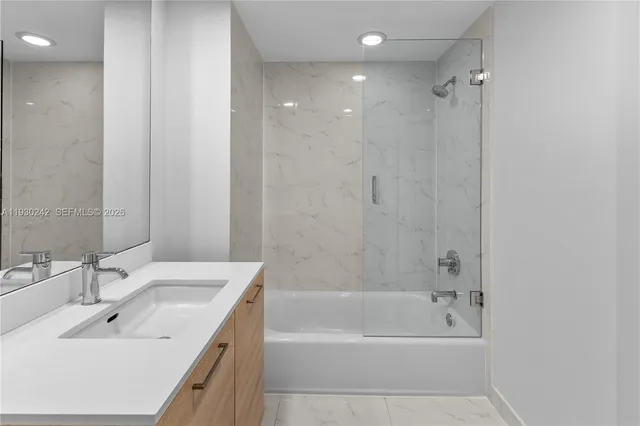 a bathroom with a shower sink and mirror