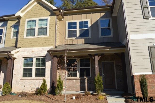690 Wickham Ridge Road, Unit 141 Apex, NC 27539 - Photo 2 of 25 front view of a brick house with a large window