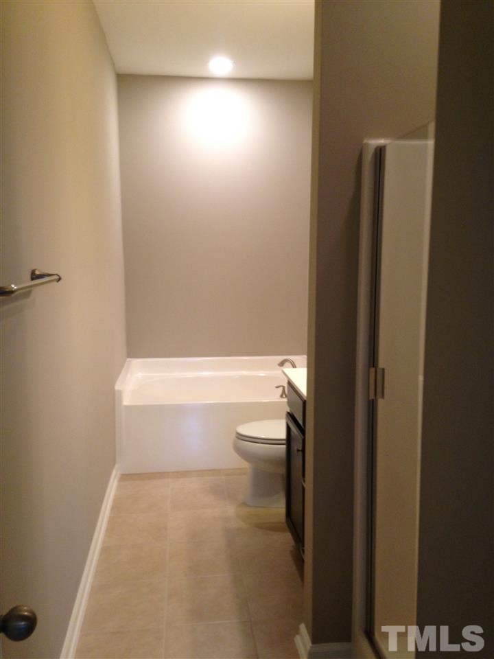 690 Wickham Ridge Road, Unit 141 Apex, NC 27539 - Photo 15 of 25 a bathroom with a shower and a toilet