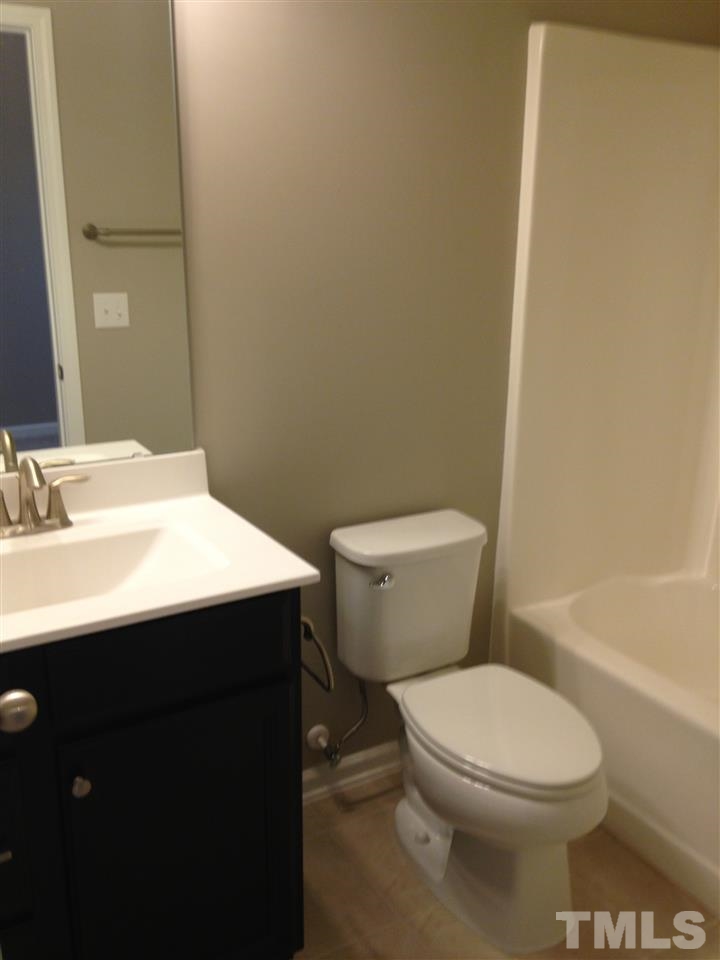 690 Wickham Ridge Road, Unit 141 Apex, NC 27539 - Photo 22 of 25 a bathroom with a sink a toilet and shower