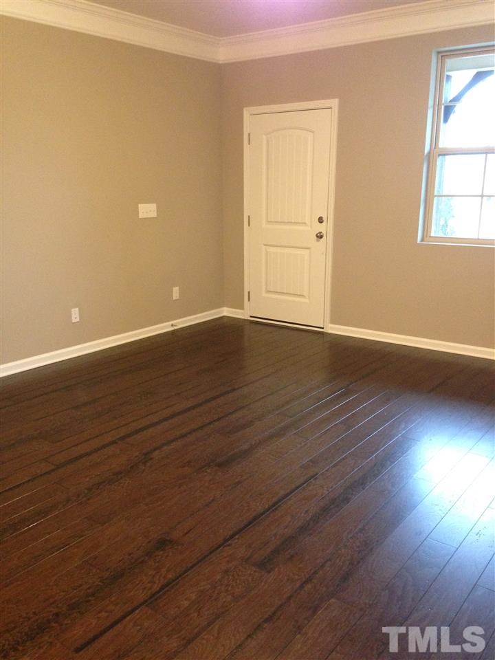 690 Wickham Ridge Road, Unit 141 Apex, NC 27539 - Photo 6 of 25 wooden floor in an empty room with a window