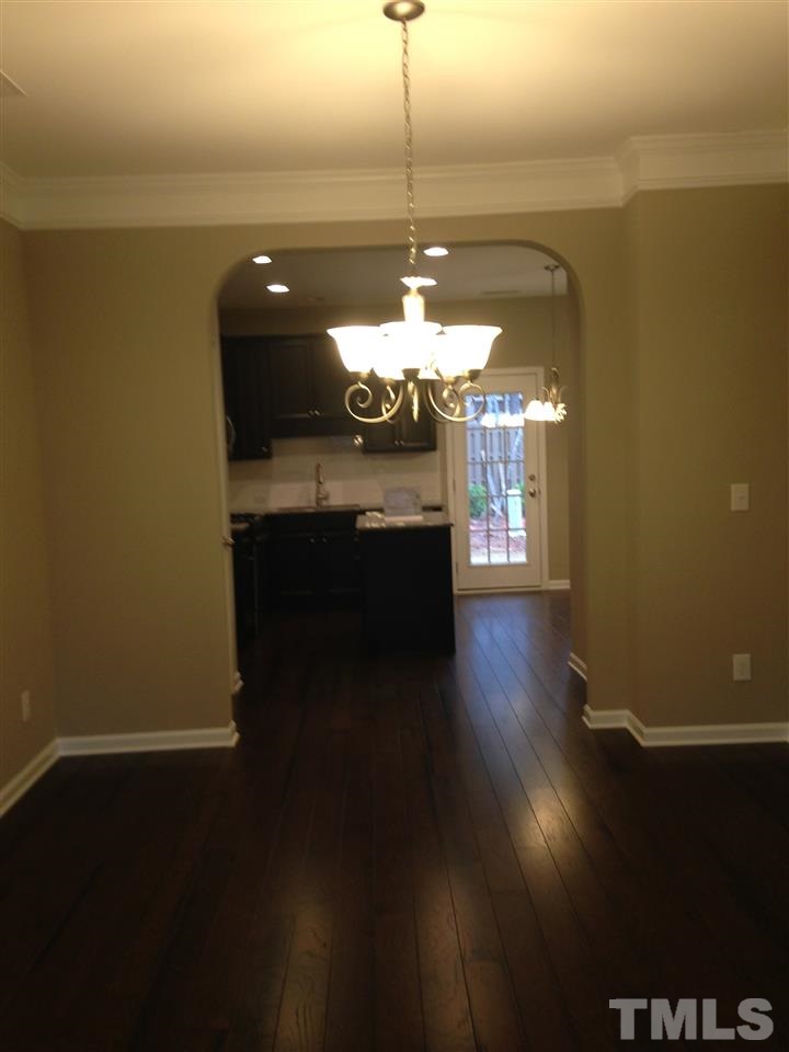 690 Wickham Ridge Road, Unit 141 Apex, NC 27539 - Photo 7 of 25 a view of a room with wooden floor and a ceiling fan