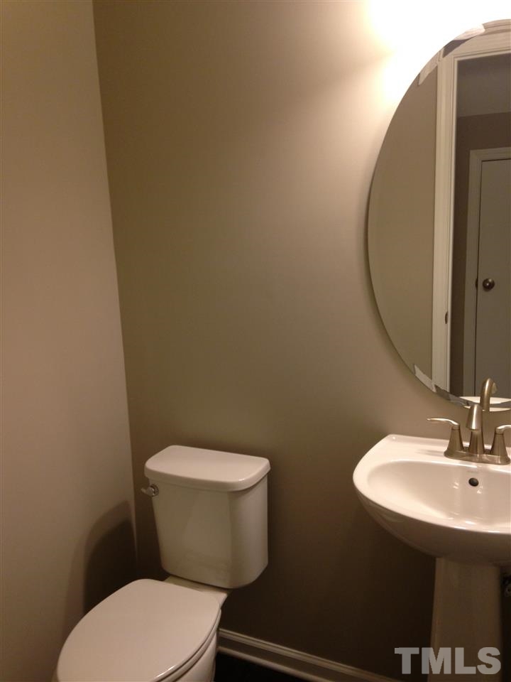 690 Wickham Ridge Road, Unit 141 Apex, NC 27539 - Photo 8 of 25 a white toilet sitting next to a bathroom sink