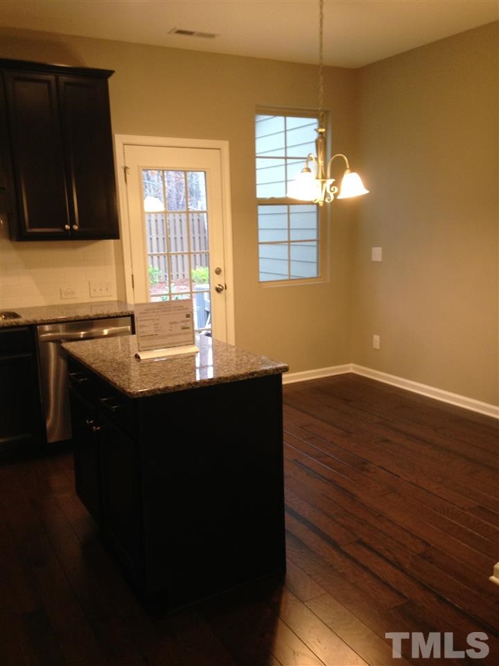 690 Wickham Ridge Road, Unit 141 Apex, NC 27539 - Photo 10 of 25 a kitchen with wooden cabinets and a sink