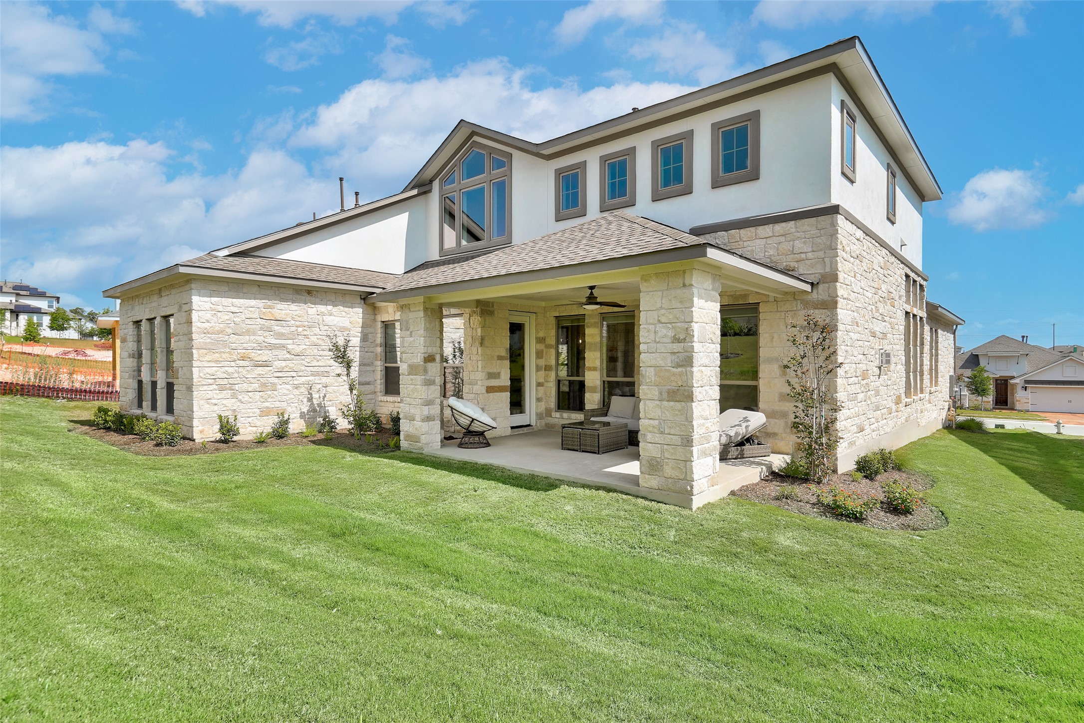 720 Rawson Bend Austin, TX 78738 - Photo 32 of 40 Rear view of property featuring stone siding, a ceiling fan, a patio area, and a lawn