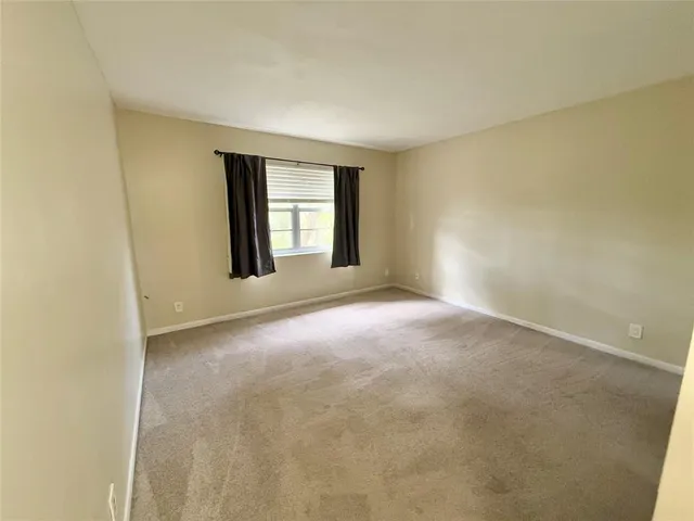 a view of a big room with windows and chandelier fan