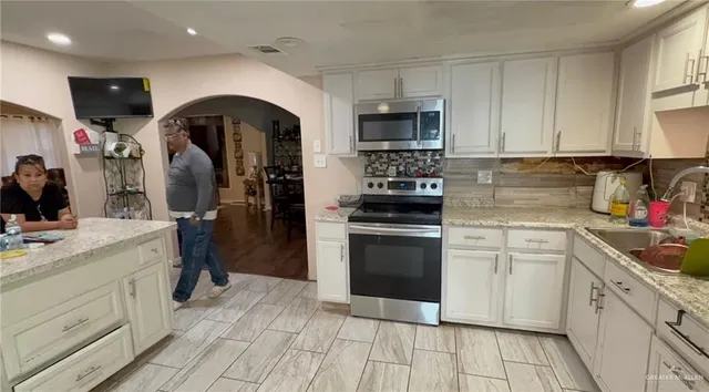 a kitchen with stainless steel appliances granite countertop a sink and cabinets