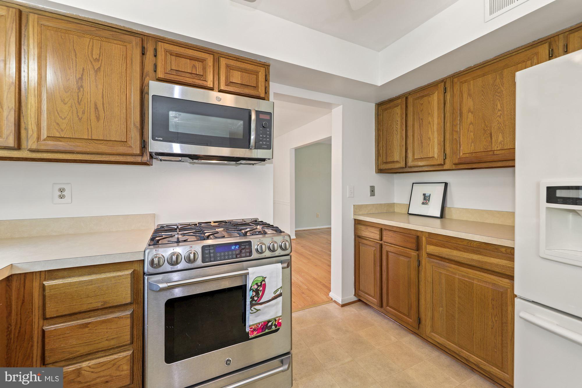 11321 Classical Lane Silver Spring, MD 20901 - Photo 11 of 35 a kitchen with stainless steel appliances granite countertop a stove microwave and sink