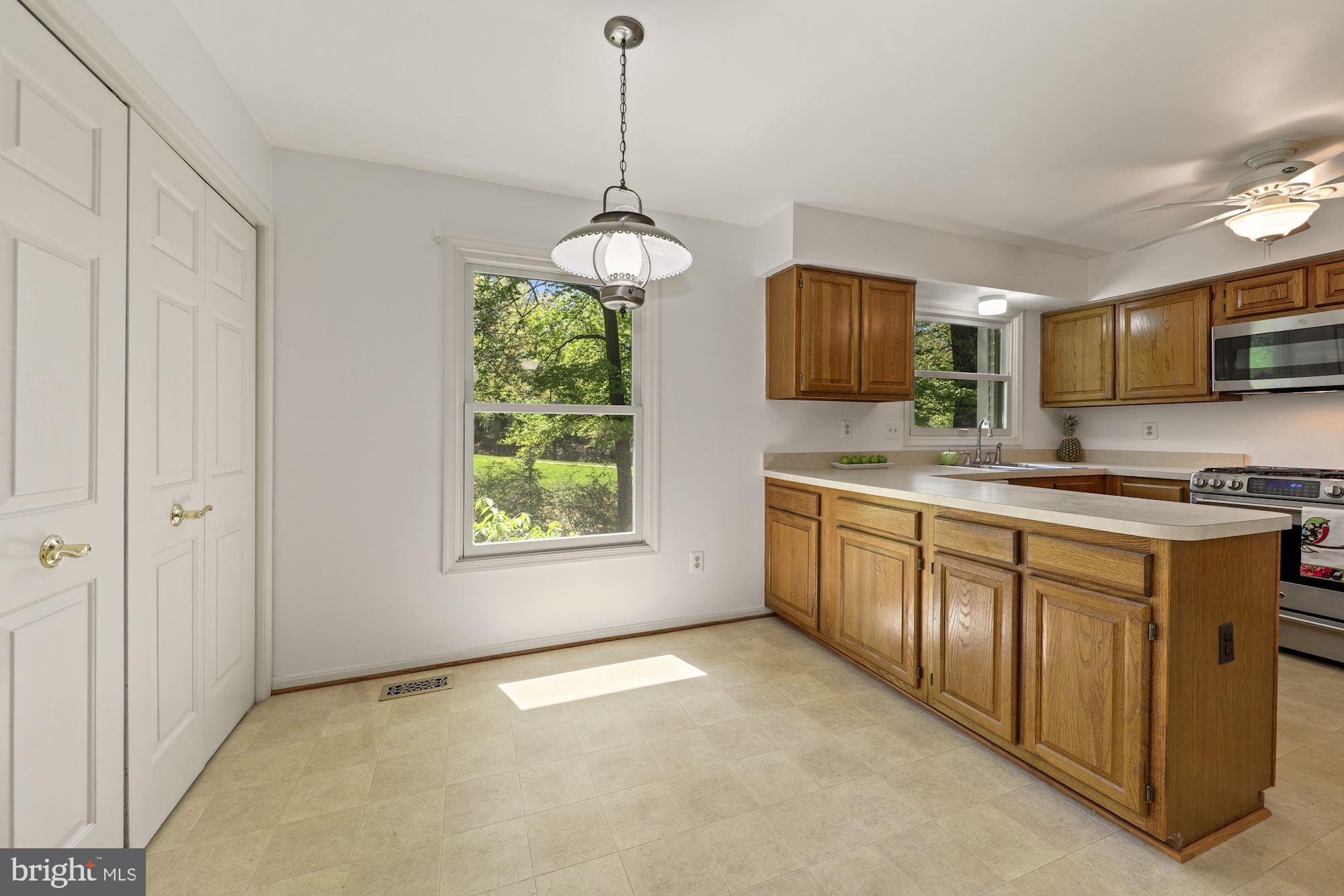 11321 Classical Lane Silver Spring, MD 20901 - Photo 12 of 35 a kitchen with stainless steel appliances granite countertop a stove sink and microwave